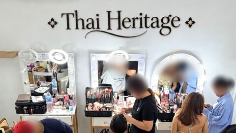 ห้องแต่งหน้าใต้ป้ายชื่อ Thai Heritage มีกระจกติดไฟและโต๊ะแต่งหน้า