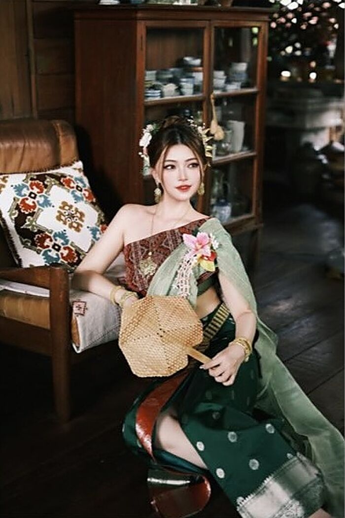 ชุดตะไคร่น้ำ: ผ้าคลุมไหล่สีเขียวหม่นกับผ้านุ่งสีเขียวเข้มลายจุดสีเงิน นั่งถือพัดสาน